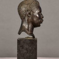 Alt text: Bronze bust of the head of a boxer