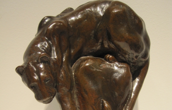 Alt text: Bronze sculpture of a panther climbing down from its post