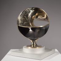 Alt text: Abstract bronze sculpture of circles polished and warped