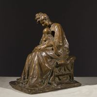 Alt text: Bronze sculpture of a mother tending to the baby seated on her lap