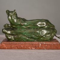 Alt text: Bronze sculpture of a reclining lioness