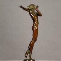 Alt text: Bronze sculpture of a nude woman posing with her right arm extended to the side