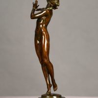 Alt text: Bronze sculpture of a nude woman posing with her right arm extended to the side