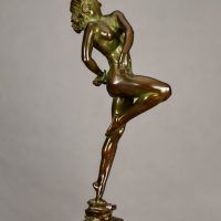 Alt text: Bronze sculpture of a nude woman skipping and holding a fish in one hand