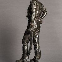 Alt text: Bronze sculpture of a telephone linesman in work gear