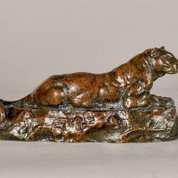 Alt text: Bronze sculpture of a lounging Tunisian panther