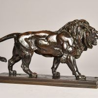 Alt text: Bronze sculpture of a  male lion walking