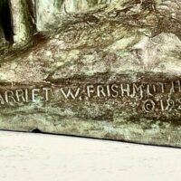 Alt text: Bronze sculpture signature detail