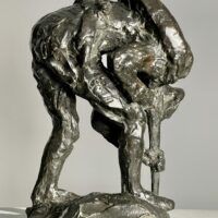 Alt text: Bronze sculpture of a bending man