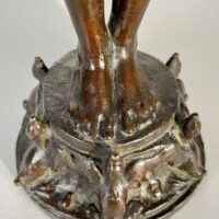 Alt text: Detail of bronze fountain sculpture of Pan playing flute