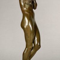 Alt text: Bronze sculpture of a nude woman standing and cradling grapes over her shoulder and into her chest, side view