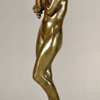 Alt text: Bronze sculpture of a nude woman standing and cradling grapes over her shoulder and into her chest, angled view
