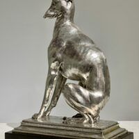 Alt text: Silvered bronze sculpture of a seated dog