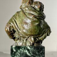 Alt text: Bronze sculpture of woman with child on her back