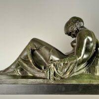 Alt text: Bronze sculpture of a reclining woman