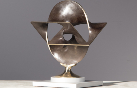 Alt text: Abstract bronze sculpture of two distorted and conjoined squares and one circle