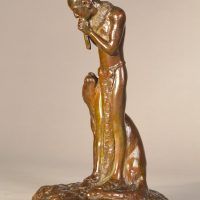 Alt text: Bronze sculpture of a Native American man playing flute, looking down at a Puma sitting beside him, angled view
