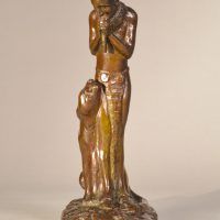 Alt text: Bronze sculpture of a Native American man playing flute, looking down at a Puma sitting beside him, frontal view