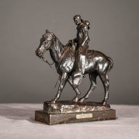 Alt text: Bronze sculpture of a cowboy riding on a horse