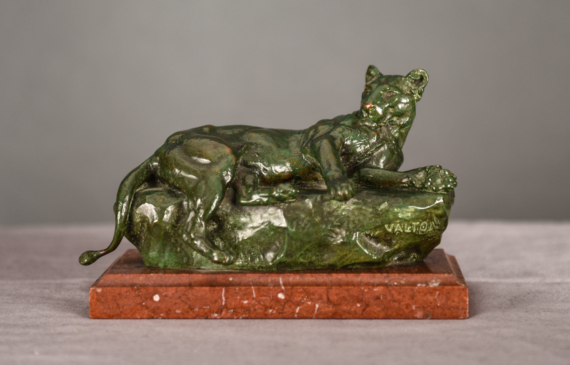Alt text: Bronze sculpture of a reclining lioness