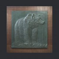 Alt text: Bronze relief of a grizzly bear