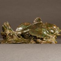 Alt text: Bronze sculpture of a sculpin fish atop the water