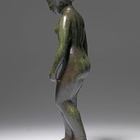 Alt text: Smooth bronze sculpture of a standing nude woman holding draped fabric