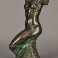 Alt text: Bronze sculpture of a headless and armless seated female nude