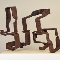 Alt text: Abstract steel sculptures resembling two figures side by side, angled view