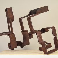 Alt text: Abstract steel sculptures resembling two figures side by side, rear view
