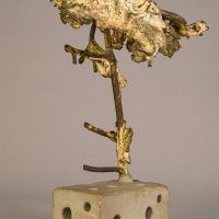 Alt text: Welded bronze sculpture shaped like a tree mounted on a slag block, angled view