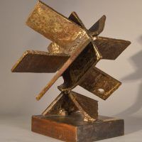 Alt text: Welded steel sculpture with many panels or blades, resembling a fan, angled view