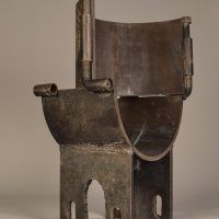 Alt text: Steel sculpture in the shape of a small chair with rounded seat, angled view