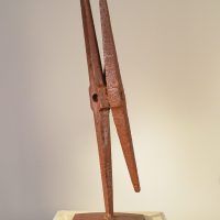Alt text: Welded pickaxe sculpture resembling a propeller, side view