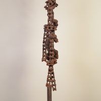 Alt text: Welded chain link sculpture with biomorphic figure, side view