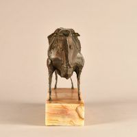 Alt text: Bronze modernist sculpture of a bull atop a marble base