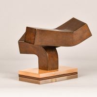 Alt text: Abstract steel sculpture with three blocky sections atop a base