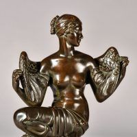 Alt text: Bronze sculpture of Philomela from Greek mythology, kneeling with wings growing from her back