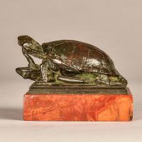 Alt text: Small bronze sculpture of a turtle eating a frog