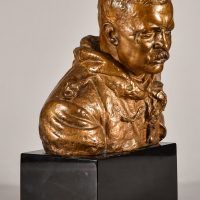Alt text: Bronze sculpture of Teddy Roosevelt with a stern expression as a rough rider