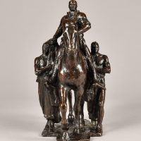 Alt text: Bronze sculpture of Teddy Roosevelt riding a horse flanked by two Native American men on the ground, frontal view