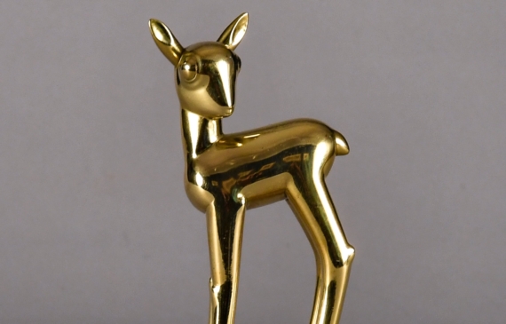 Alt text: Polished bronze sculpture of a long-legged fawn