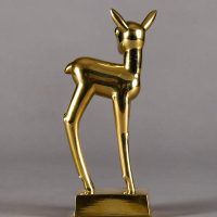 Alt text: Polished bronze sculpture of a long-legged fawn