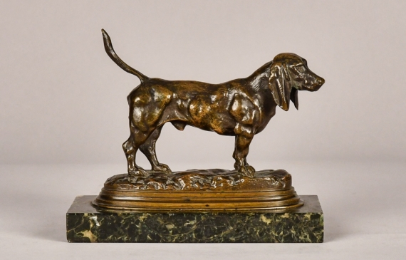 Alt text: Bronze sculpture of a Basset Hound with tale up, angled view