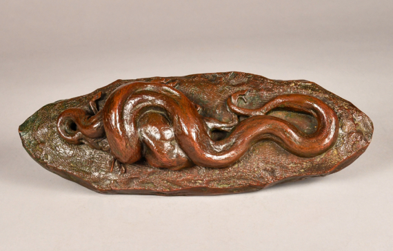 Alt text: Bronze sculpture of a giant python eating a deer