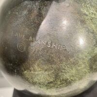 Alt text: Signature detail of a bronze sculpture of an allegorical figure