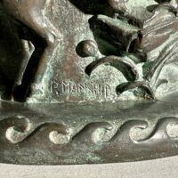 Alt text: Bronze sculpture of a bear on a pedestal, detail