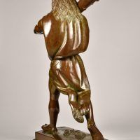 Alt text: Bronze sculpture of Hercules cloaked in a lion skin holding a raised club