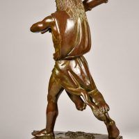 Alt text: Bronze sculpture of Hercules cloaked in a lion skin holding a raised club