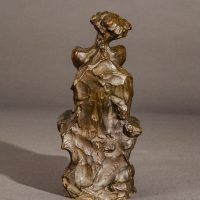 Alt text: Bronze sculpture of a nude woman sitting and reclining, rear view